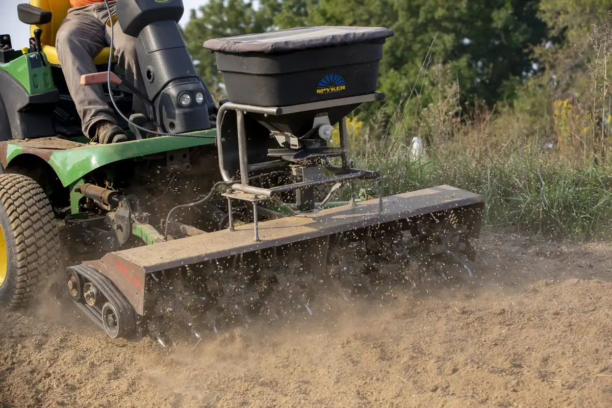 A tractor-mounted aerator working the soil on a north-central Illinois lawn in fall